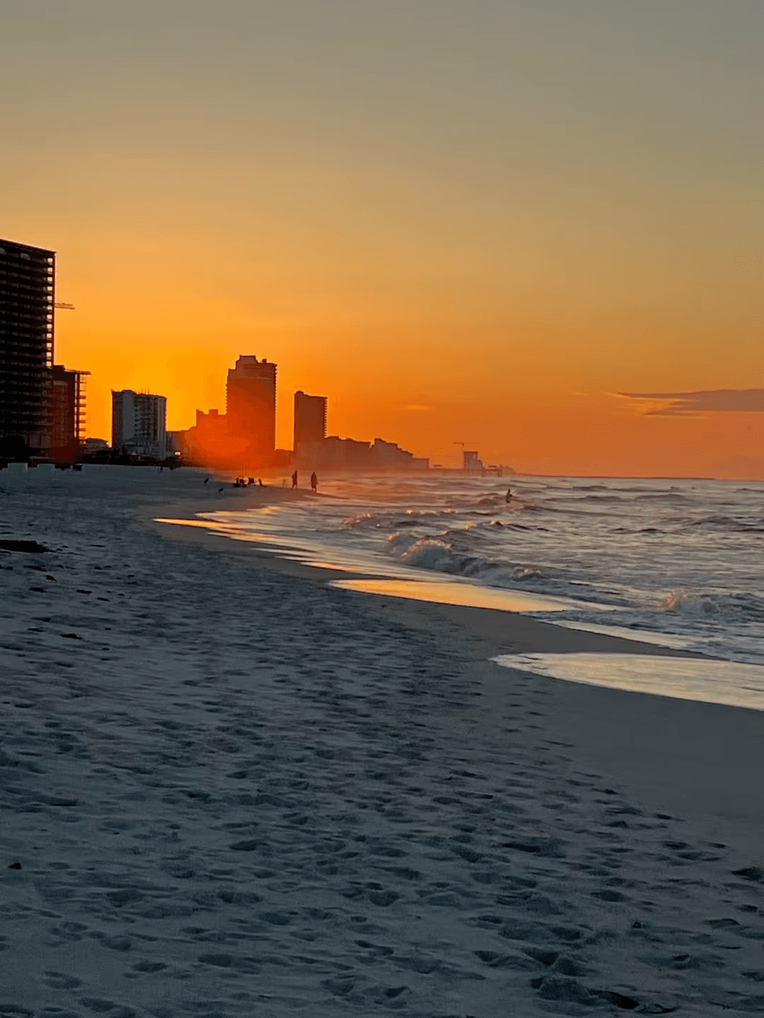 Sunset over the Orange Beach shoreline, condo skyline on the horizon